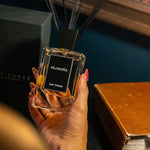 Hand holding a 'Filosofia' perfume bottle with a blurred background